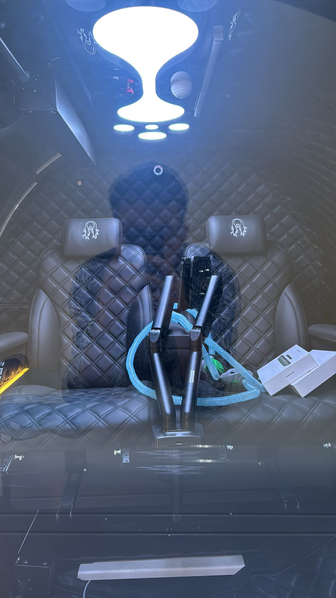 Interior view through the chamber window showing quilted leather seating and embroidered headrests