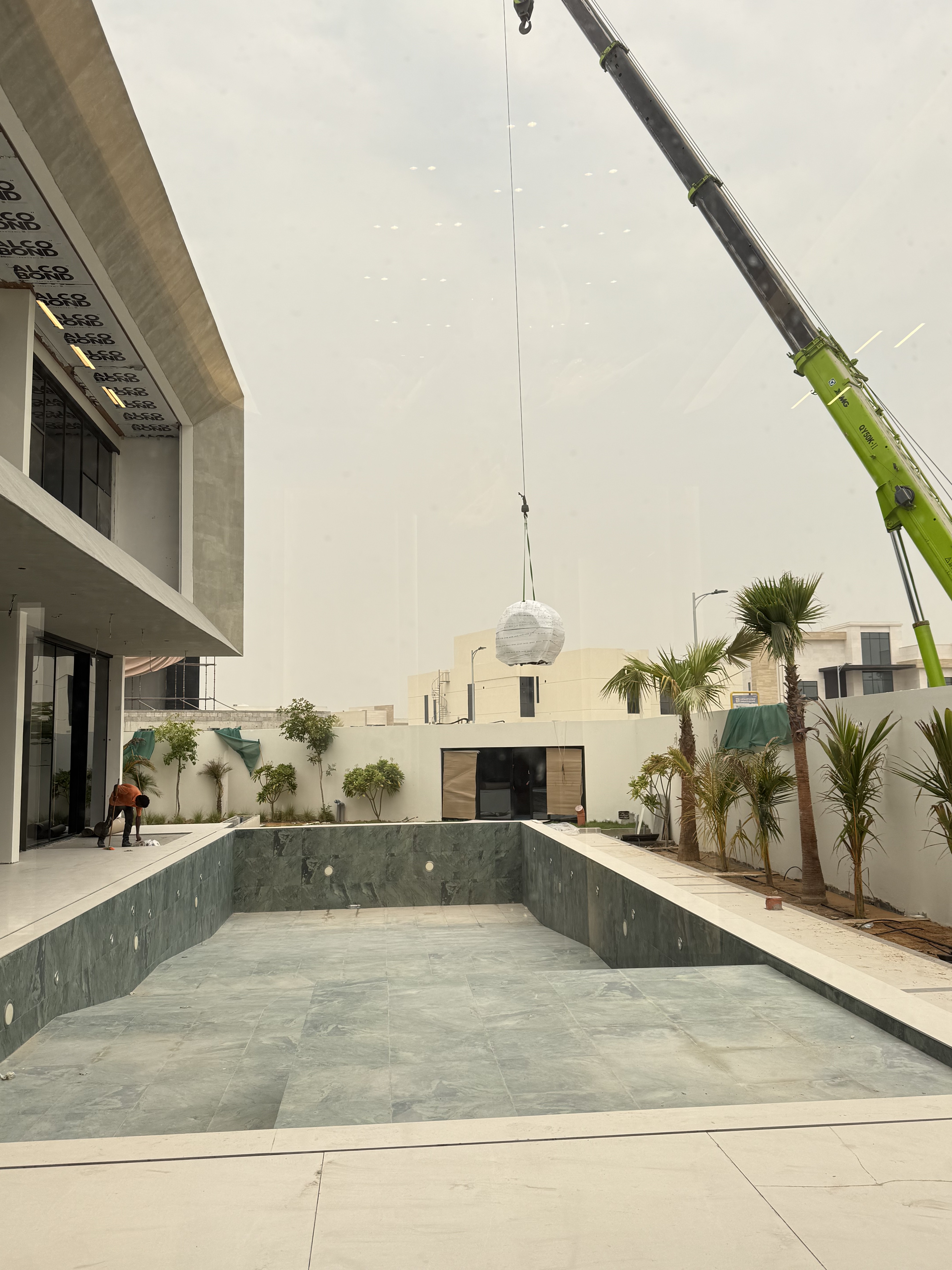 Recovery pod craned over the villa courtyard during installation