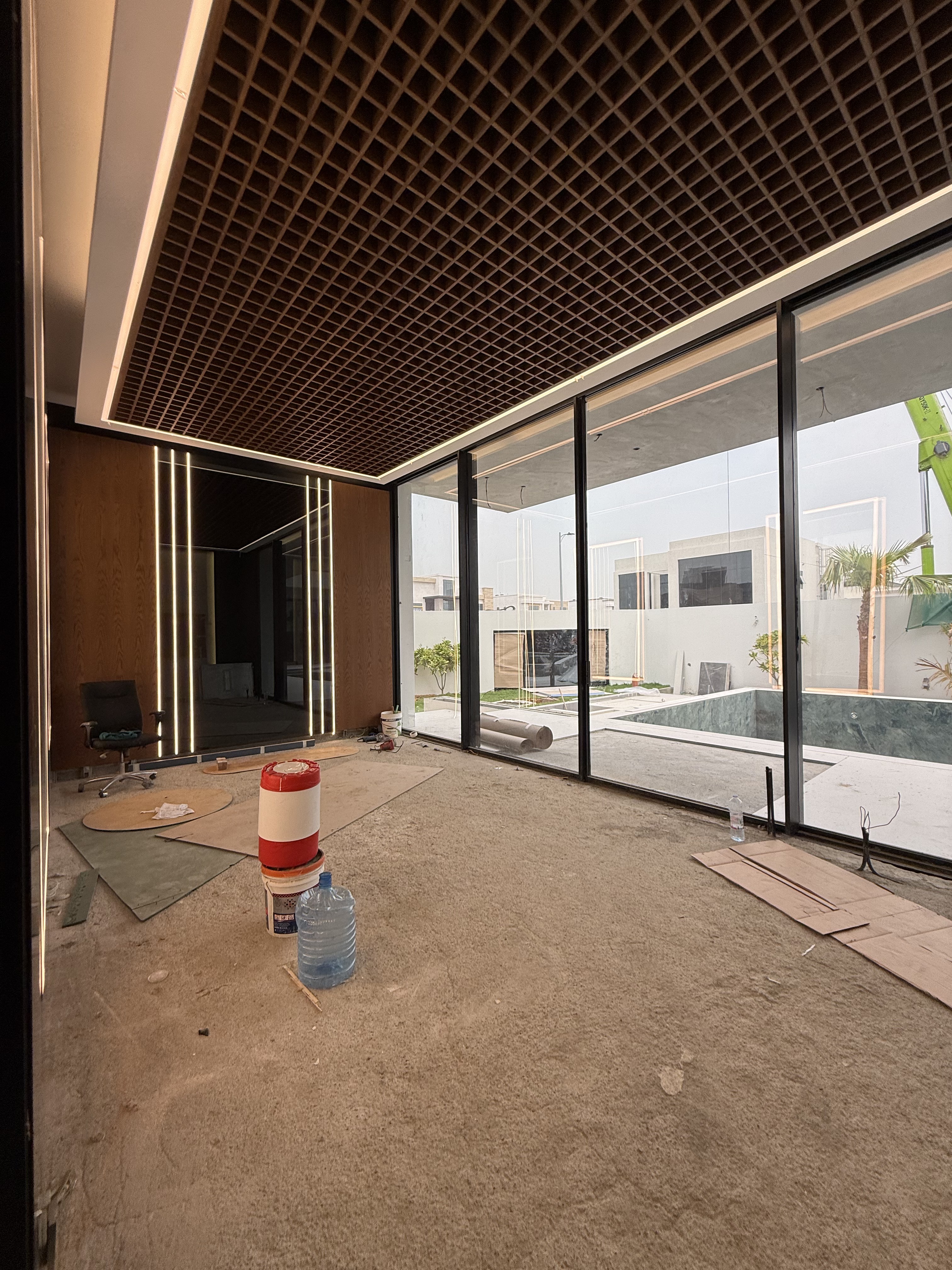 The villa wellness room before fit-out, bare concrete floor with timber ceiling and pool beyond