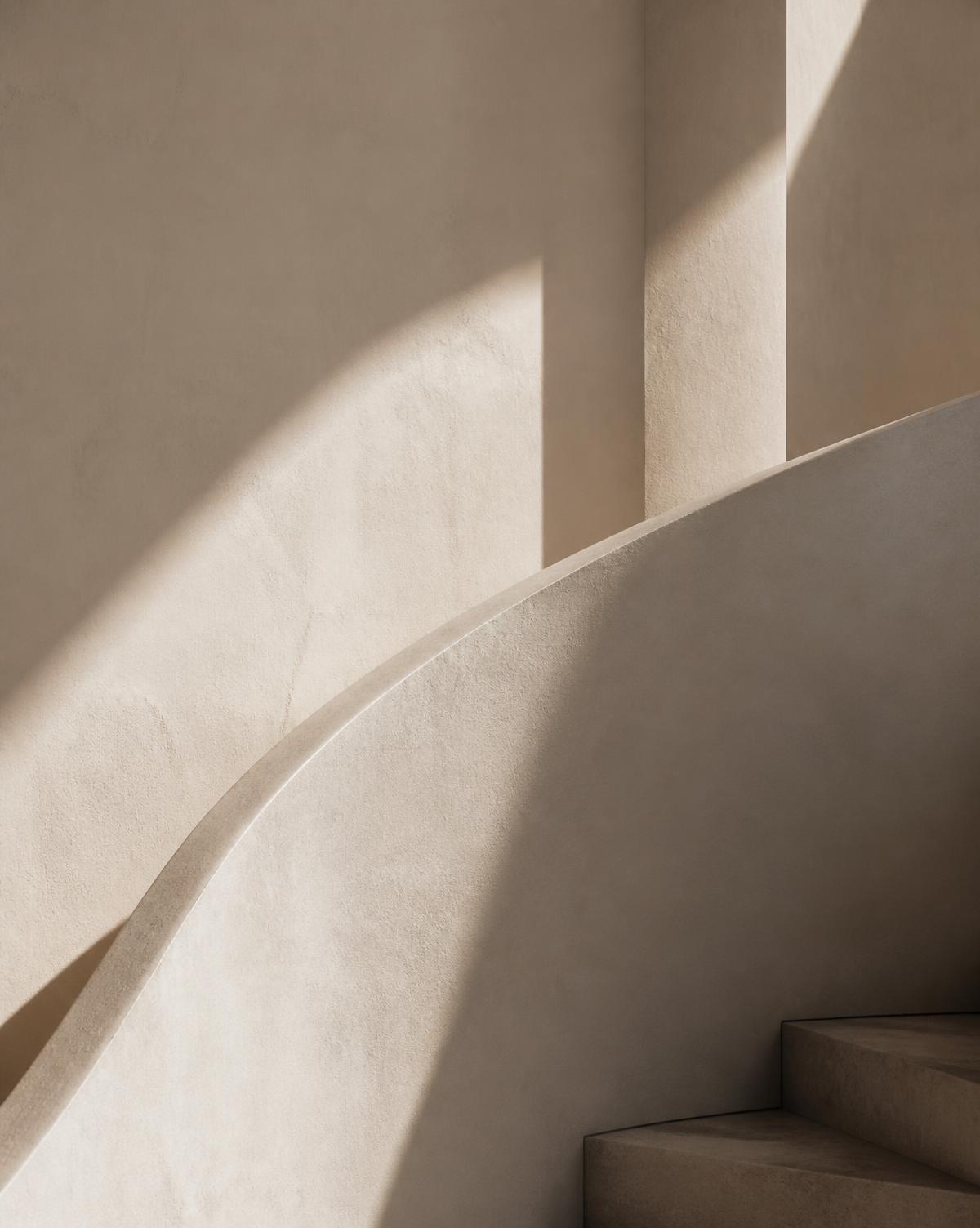 Soft daylight across a curved plaster stair in a minimal warm interior